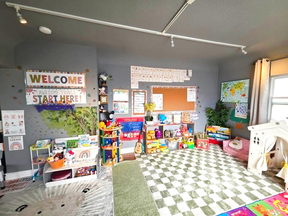 Happy Sprouts welcome wall, reading nook, and bright open play area with a soft green checkered rug